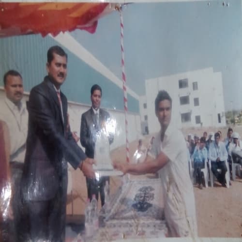 Student receiving a sports trophy at a prize distribution