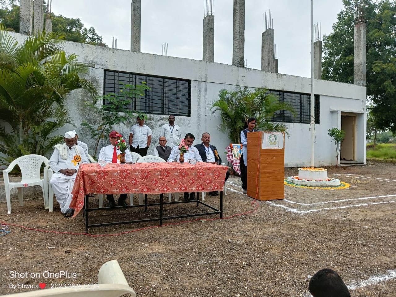 Dignitaries on the dais at an outdoor campus function
